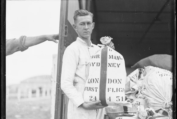 Young man loading the first air mail for England on to the Southern Sun, 24 April 1931