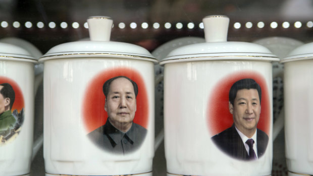 Porcelain cups featuring portraits of Chinese President Xi Jinping, right, and former Chinese leader Mao Zedong in a store window in Beijing,