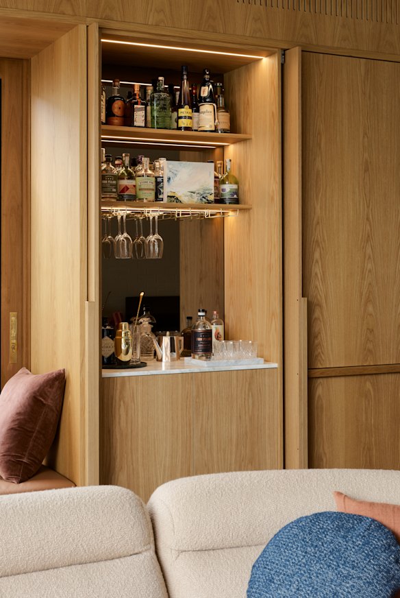 Reflective surfaces and pocket doors create a little mystery and increase serviceability in this bar by Studio Johnston.