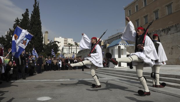 Protesters watch the changing of the Presidential Guard during the rally in Athens on Sunday.