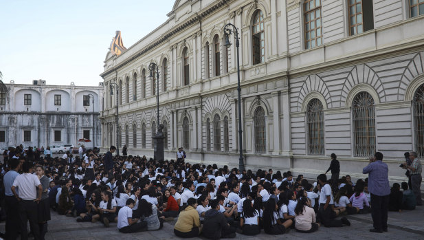 Students from a public school sit in an open area after being evacuated, in Veracruz, Mexico.