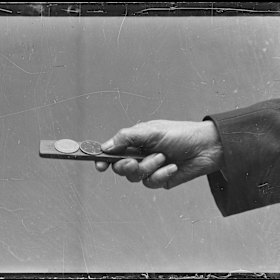 A kip with two coins held by a spinner at an illegal two-up school on Reservoir Street, Surry Hills in 1930.