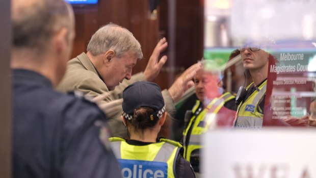 Cardinal George Pell goes through security at Melbourne Magistrates Court on Monday morning.