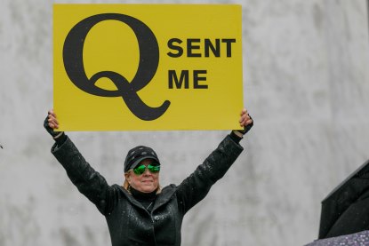 A supporter of Q-Anon conspiracy theorists holds a sign during protests in the US.