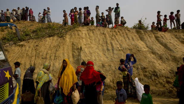 Rohingya Muslims watch from atop a hill as new refugees arrive in Bangladesh.