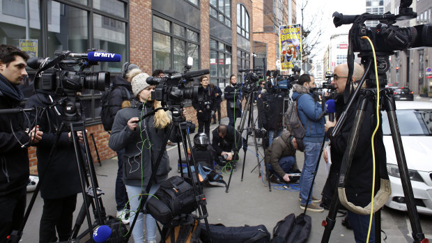 Reporters gather outside the police station where Nicolas Sarkozy was held while giving testimony.