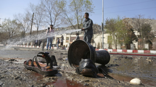 Afghan firefighters clean up the site of the deadly  bombing.