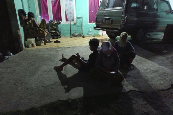 People wait outside their homes following an earthquake in Bantul district, outside Yogyakarta in Indonesia.