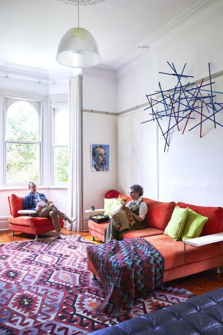 Chris Packer and Selina Samuels in the formal living room in the old part of their house, where vintage features are offset by modern furniture, light fittings and Packer’s contemporary artworks.