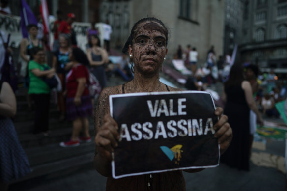 An activists covered in mud poses with a sign that reads "Vale assassin" during a demonstration on the front steps of Sao Paulo's Cathedral in Brazil last week.