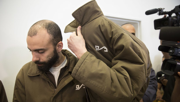 French consulate worker Romain Franck, a French employee of France's Consulate in Jerusalem, covers his face during a hearing at the district court in in the southern Israeli city of Beersheba, on Monday.