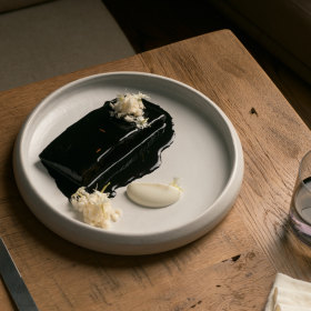 Squid ink glazed toothfish, cauliflower, and phlox flowers.
