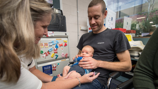 Luka Stahli Quinn receives his shot from immunisation nurse Robyn Roche, as dad Mark Quinn looks on.