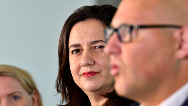 Queensland Premier Annastacia Palaszczuk (left) looks on while Queensland Treasurer Curtis Pitt (right) addresses the media.