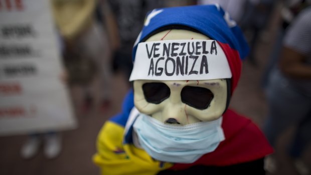 A woman with a message on her forehead that reads  'Venezuela agonises' during a protest demanding the government attend to the country's health crisis.