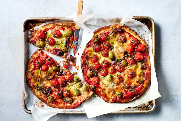 Lebanese bread stands in for dough so you can make these summer puttanesca pizzas in 20 minutes.