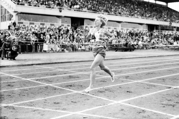 Betty Cuthbert hits the tape in a new world record time.