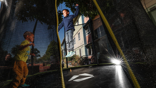 Amaniel and Isaiah play on their trampoline before it is taken away.