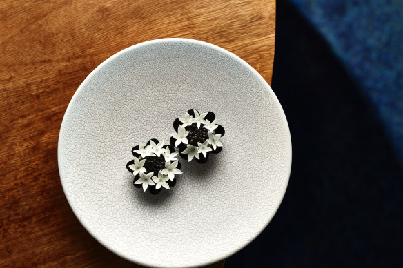 Amuse-bouche tart with creme fraiche and oscietra caviar.