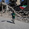 A boy waves an Iranian flag in front a police facility struck during the US-Israeli military campaign in Tehran, Iran, on Wednesday.