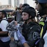 A baby is carried away from the site of an Iranian missile attack in Israel.