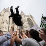 A newly ordained Catholic priest is launched in the air by friends and family outside the Duomo Cathedral after his ordination ceremony in Milan, Italy.