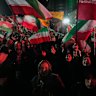 Pro-government demonstrators wave Iranian flags in Tehran on Monday.