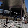 Palestinians survey the destruction at a school used as a shelter after it was struck by an Israeli airstrike in Gaza City.