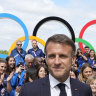 French President Emmanuel Macron poses with French athletes as he visits the Olympic Village on Monday.