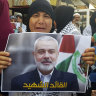 A Hamas supporter holds a poster of its political chief Ismail Haniyeh during a protest to condemn his killing.