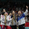 South Korean table tennis players, wearing blue, take a so-called victory selfie on the podium with a team from North Korea.