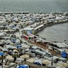 A tent camp for displaced Palestinians stretches across the Gaza City seaport.