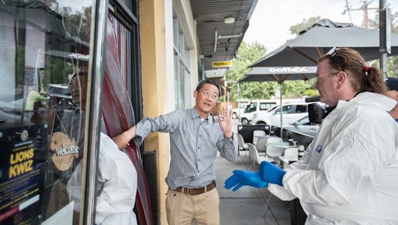 Owner Sean Wang letting in the forensic cleaners to the shop.
