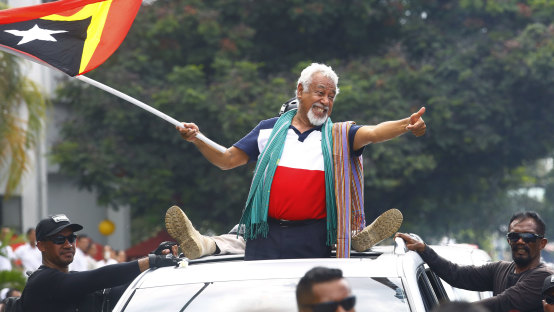 East Timorese independence hero Xanana Gusmao waves a national flag upon arrival in Dili on Sunday.