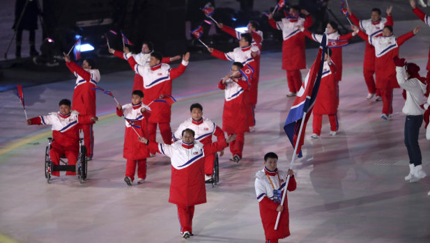 Kim Jong Hyon carries the flag of North Korea as he leads his teammates into the opening ceremony.