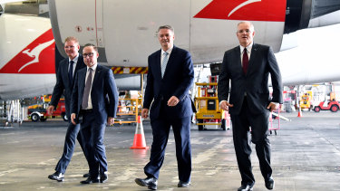 Assistant Minister for Multicultural Affairs Craig Laundy, Qantas CEO Alan Joyce, acting Prime Minister Mathias Cormann and Treasurer Scott Morrison call for company tax cuts at the Qantas hanger. 
