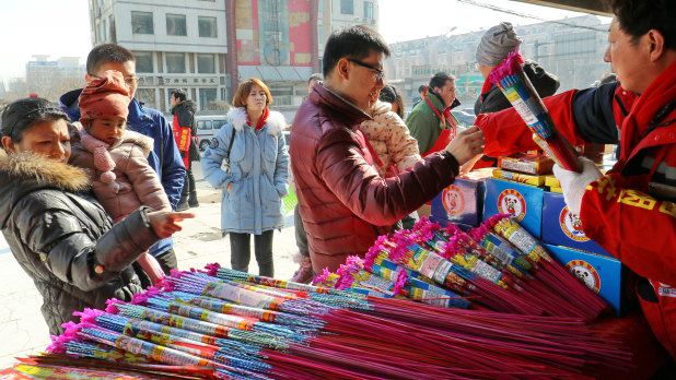 People buy fireworks and crackers at a stand in Chaoyang District of Beijing ahead of Chinese New Year celebrations on Friday. 