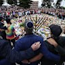 Mourners gather at Bondi Pavilion’s floral memorial at for victims of the massacre on Sunday.