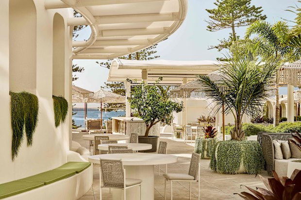 The outdoor area of a hotel with chairs and lounges