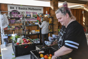 Kelly Warren, right, sorts vegetables while a customer browses for free goods at Bk 2 Basics Melbourne in Narre Warren.