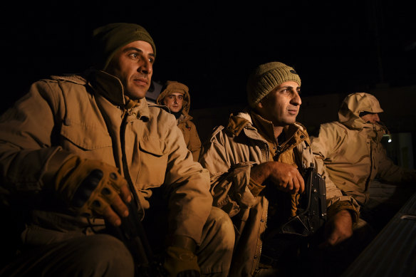 Peshmerga soldiers in the back of a ute wait to start their night patrol of the border between Iraqi Kurdistan and Syria.