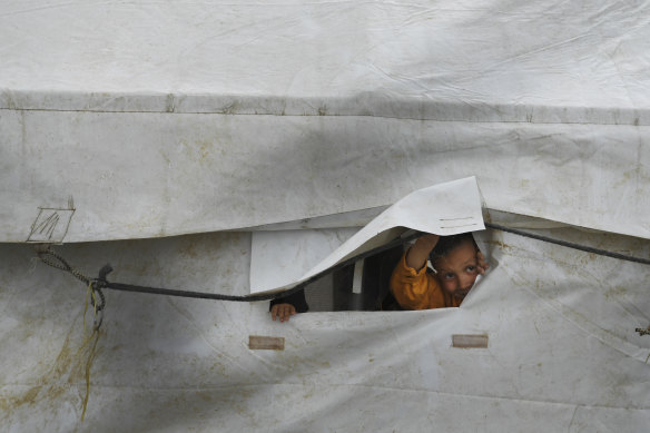 On the outside looking in: a child peeks through the flap of a tent in the foreign section of al-Hawl camp in Syria.