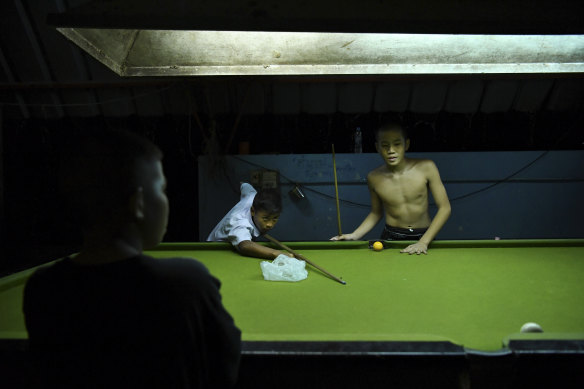 Ek Phuton plays pool with fellow Muay Thai fighters. 