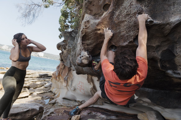 Outdoors, climbers take turn on hard routes, encouraging and advising those on the rock.