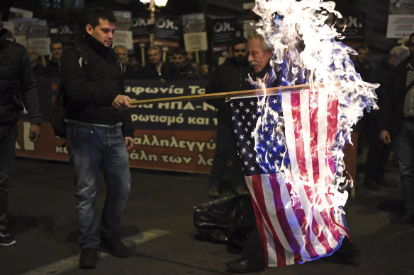 Members of the Greek Communist party set ablaze a United States flag during Thursday's rally in Athens.