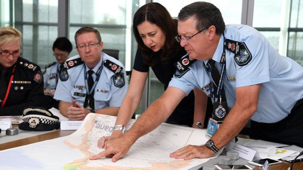 Queensland Premier Annastacia Palaszczuk (centre) is briefed by Police Commissioner Ian Stewart (right) on the floods in the state's north at the State Emergency Complex in Brisbane.