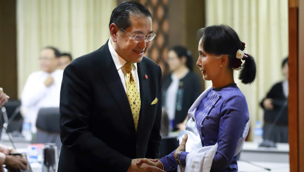 Myanmar's Foreign Minster and de facto leader Aung San Suu Kyi, right, shakes hands with Surakiart Sathirathai, left, a member of the Advisory Commission on Rakhine State on Monday.