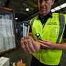An Australian Border Force officer inspects illegal cigarettes smuggled in a shipping container.