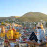 Tourist on rooftop looking at the Basilica colegiata de nuestra señora de Guanajuato and the cityscape. xxGroundwater