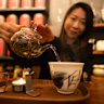 Founder of Ms. Cattea Cathy Zhang prepares Nine Mountains green tea on a candle burner.